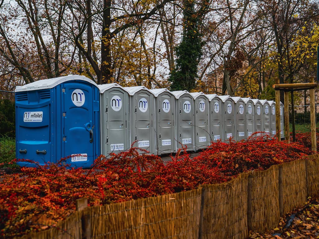 Nešiojamų biotualetų eilė parke